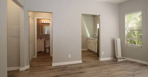 a renovated living room with a wooden floor and a bathroom