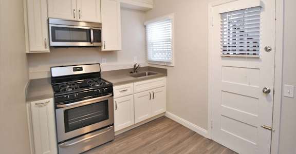 a kitchen with stainless steel appliances and white cabinets