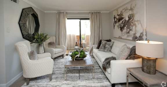 a living room with white furniture and a rug at Lodge of Overland Park Apartments, Overland Park , 66212