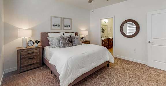 a bedroom with a bed and a ceiling fan  at Centennial Crossing, Waukee, IA