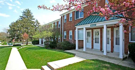 A brick building with a green roof and a sign that says 5111.