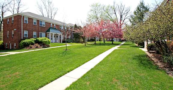A red brick building with a green lawn in front.