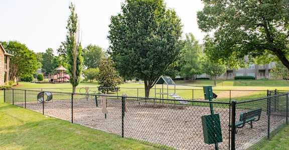 A black fence surrounds a green park area.