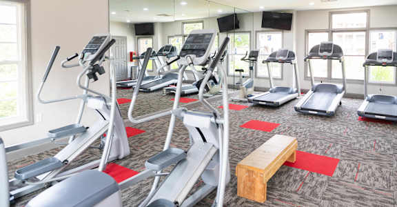 A gym with treadmills and elliptical machines.