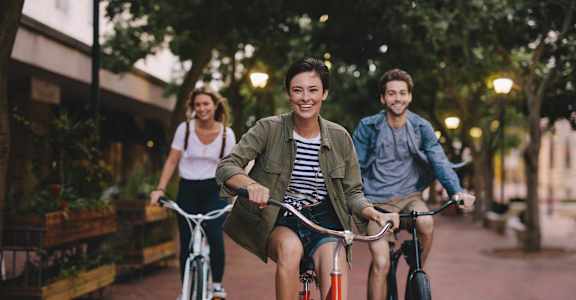 Three people riding bikes on a city street at Cordova Creek Apartments, Cordova, Tennessee