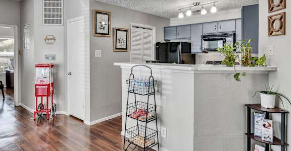 A kitchen with a white counter and a red cart.