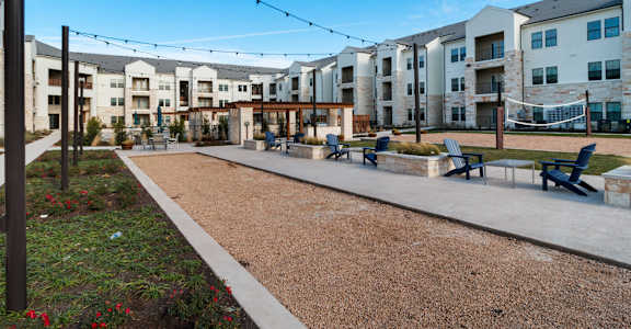 Volleyball court, patio and seating area at McCarty Commons, San Marcos, TX