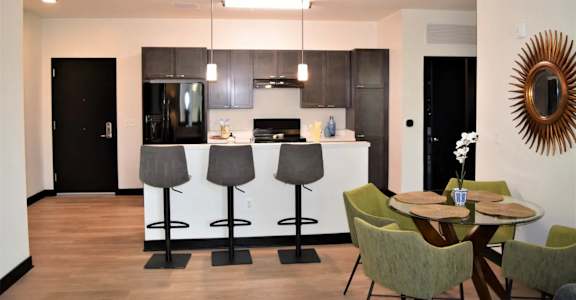 A modern kitchen with a bar area and a dining table.