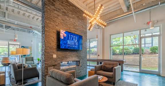 A living room with a stone pillar and a flat screen TV mounted on it.