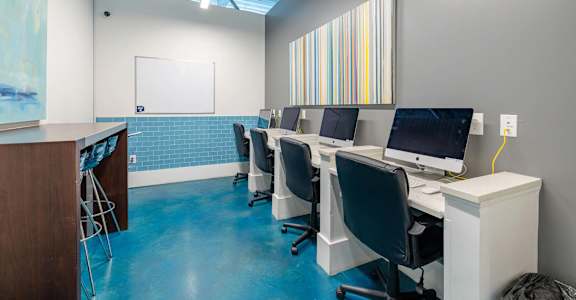 A room with blue flooring and a whiteboard on the wall.