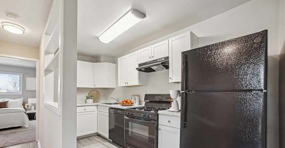 a kitchen with black appliances and white cabinets
