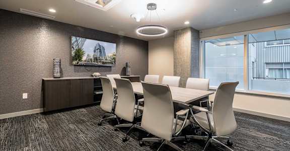 A conference room with a long table and chairs.