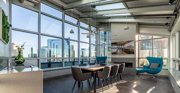 A modern dining room with a long table and chairs.