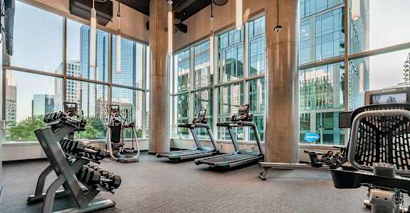 A gym with treadmills, weights, and exercise equipment.