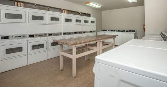 A row of white ovens are lined up in a room.