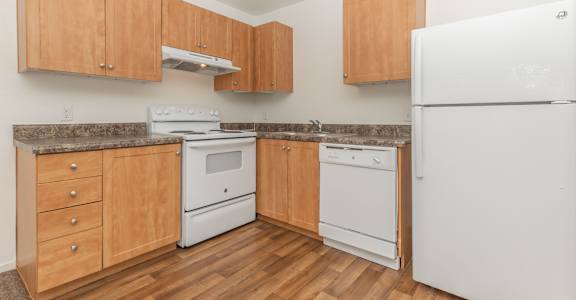 A kitchen with wooden cabinets and white appliances.