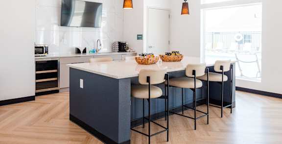 a kitchen with a large island and white and blue cabinets at Converge NW, Waukee, IA