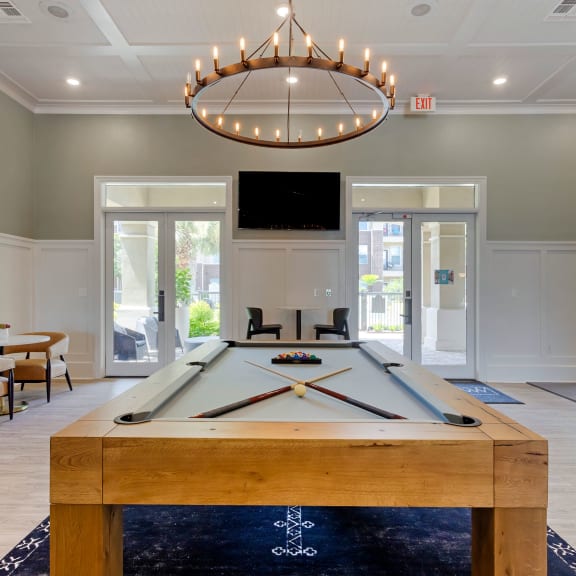 Resident Lounge with Pool Table and Ring Shaped Chandelier at Madison on the Meadow in Stafford, TX