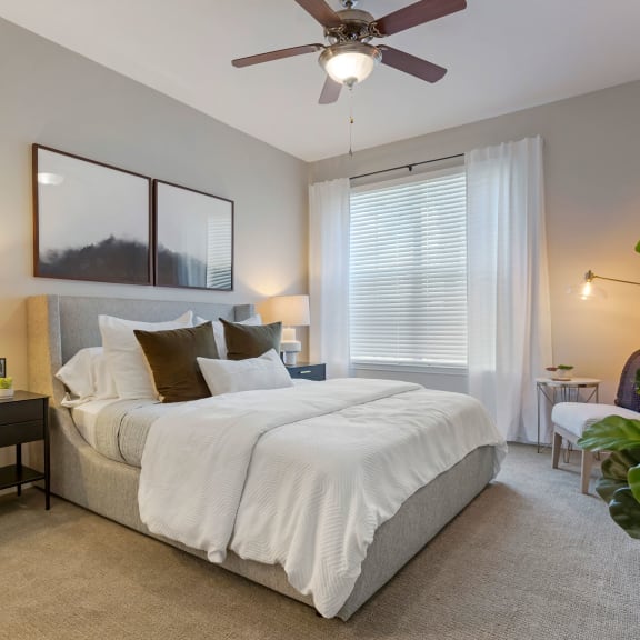 a bedroom with a large bed and a ceiling fan at Madison on the Meadow in Stafford, Texas