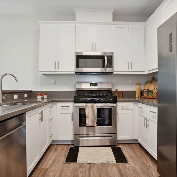 a kitchen with white cabinets and stainless steel appliances