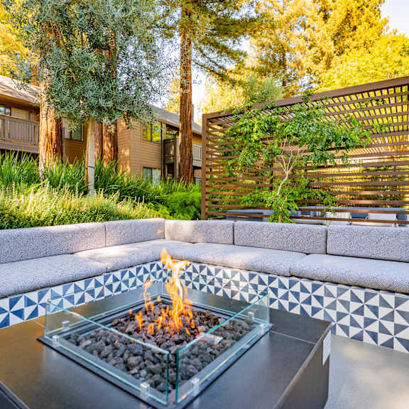 A pool area with a chair and table overlooking a body of water.