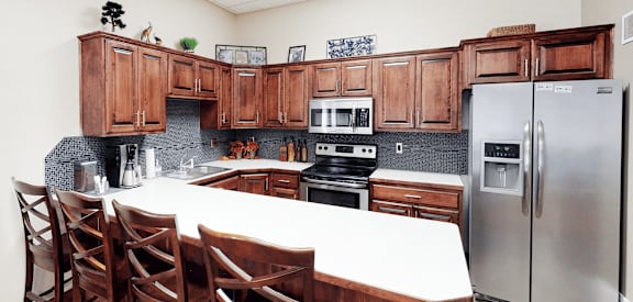 A kitchen with wooden cabinets and a white table.