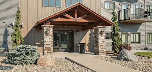 A modern building with a wooden front entrance and a balcony on the second floor.