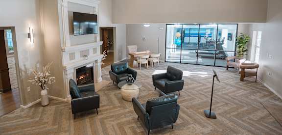 A large, well-lit room with a fireplace and comfortable seating.
