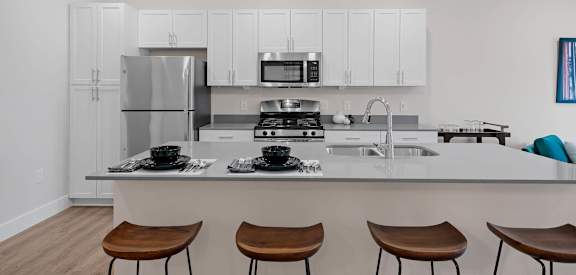 A modern kitchen with white cabinets and a center island.