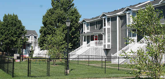 A row of houses with a black fence in front.