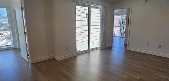 A room with wooden floors and sliding glass doors.