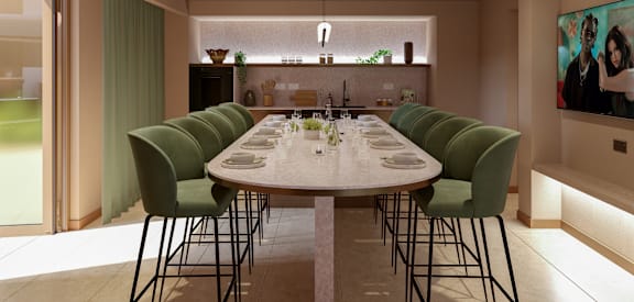 a long marble table with green chairs in a dining room