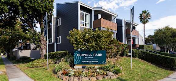 A sign in front of a building that says Bidwell Park Apartment Homes.