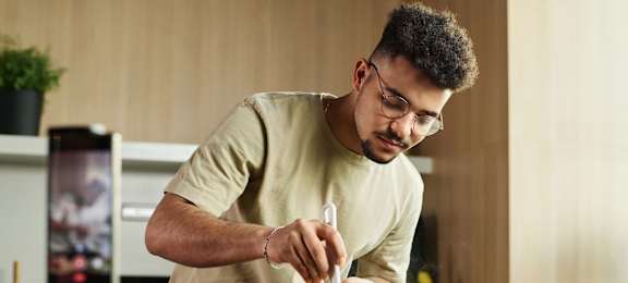 A man is cutting vegetables in a kitchen at 128 on State Apartments in Kirkland, Washington 98033
