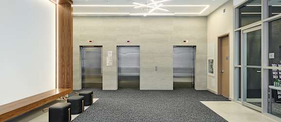 A hallway with a bench and a glass door.