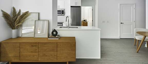 A modern kitchen with a wooden cabinet and a white countertop.