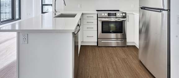 A modern kitchen with stainless steel appliances and white cabinetry.