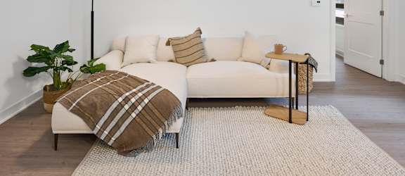 A white couch with a striped pillow and a blanket is in the center of the room.