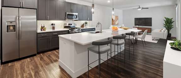A modern kitchen with a white island and stainless steel appliances.