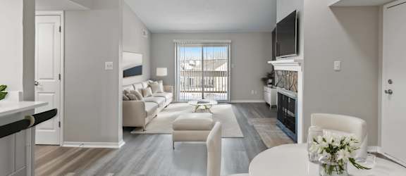 A living room with a white couch and a television on the wall.