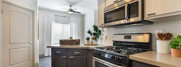 a kitchen with stainless steel appliances and wooden cabinets at Mirasol Apartments, Las Vegas, NV