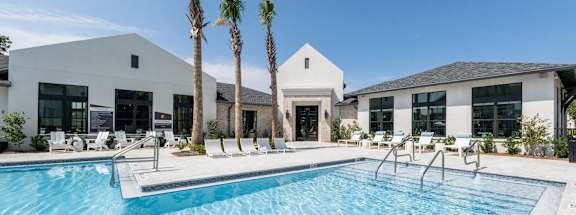a swimming pool with palm trees in front of a house at Residences at 393 North Apartments, Florida