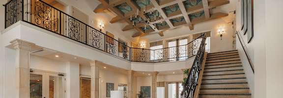 A large open space with a staircase and a table with a plant on itat The Villas at Ellis Manor, Fresno, CA