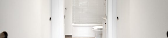 A white bathroom with a toilet and a shower.