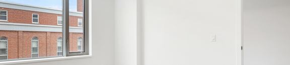 Empty room with white walls and wooden floor.