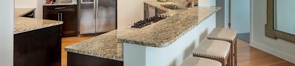 A kitchen with a granite counter top and stainless steel appliances at Residences Providence, Rhode Island