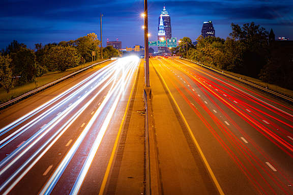A long exposure shot of a highway at night with light trails from the moving vehicles.