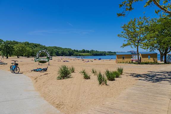 A beach scene with a bicycle parked on the sand.