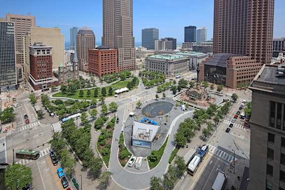 A cityscape with a large building in the center and a roundabout in front of it.