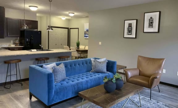 a blue couch in a living room next to a kitchen at North Pointe Villas Apartments, Lincoln